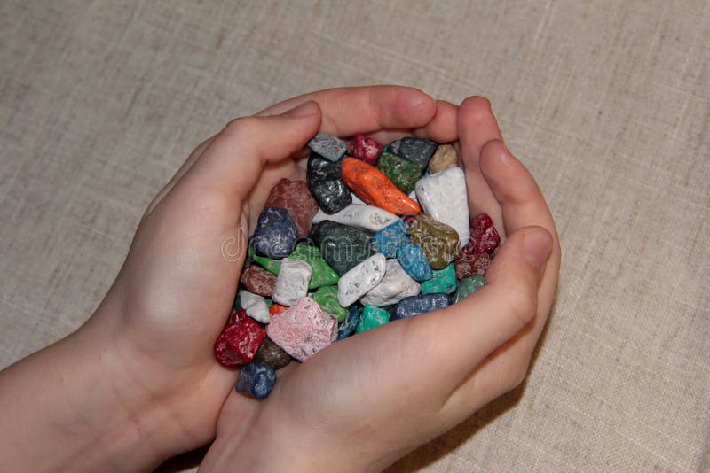 Chocolate candies in the hands of a child on a linen beige background. Sweets in the form of rubble. stock image Chocolate candies in the hands of a child on a linen beige background. Sweets in the form of rubble. stock image