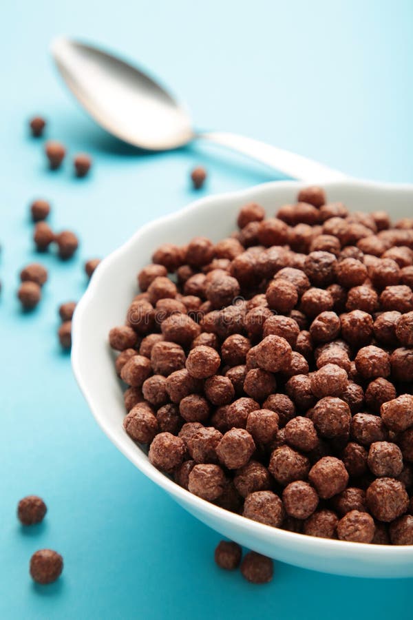 Chocolate Cereal Corn Balls in a Blue Bowl on a Purple Background Stock