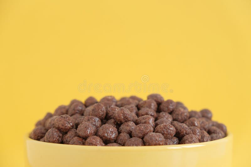 Chocolate Cereal Corn Balls in a Yellow Bowl on a Yellow Background