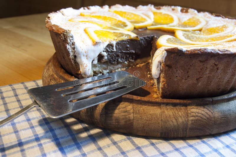 Chocolate cheesecake on a wooden board with blade for cake