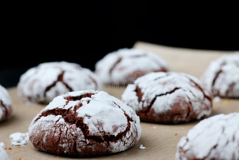 Chocolate Cookies with Cracks on Baking Paper and Iolated on Black