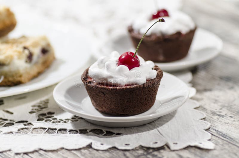 Chocolate dessert with whipped cream and a cherry