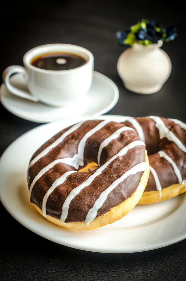 Chocolate donuts with a cup of coffee. Doughnut, black.