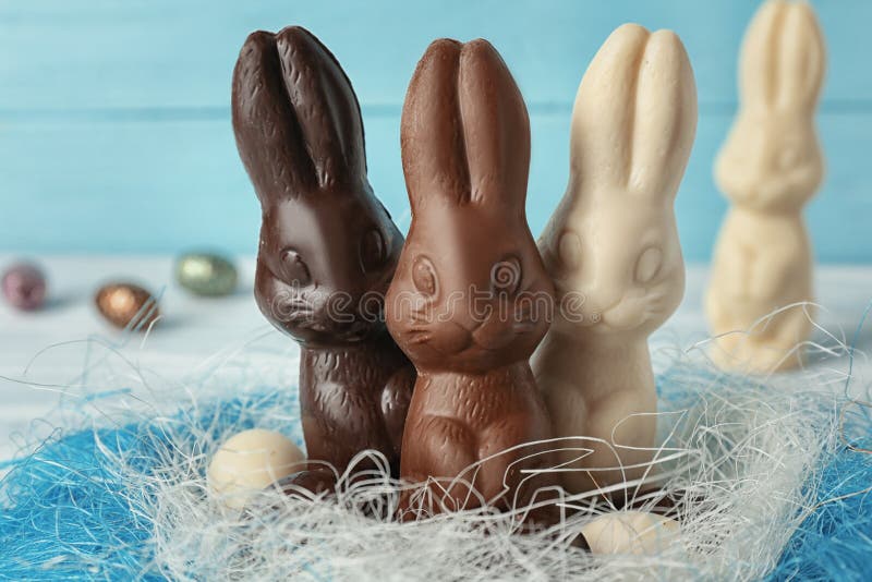 Chocolate Easter bunnies and eggs in decorative nest, closeup