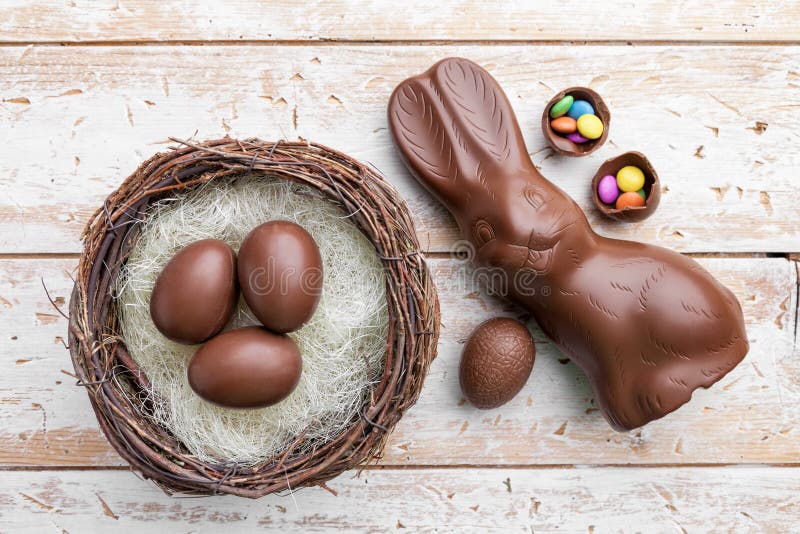 Chocolate Easter Bunny, Eggs and Sweets on Rustic Background Stock