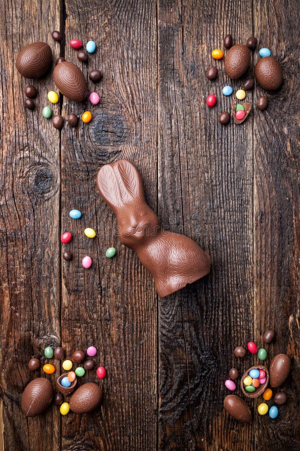 Chocolate Easter Bunny, Eggs and Sweets on Rustic Background Stock