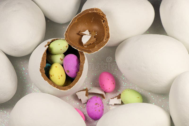 Chocolate Egg Filled with Colorful Speckled Candy Eggs Stock Photo