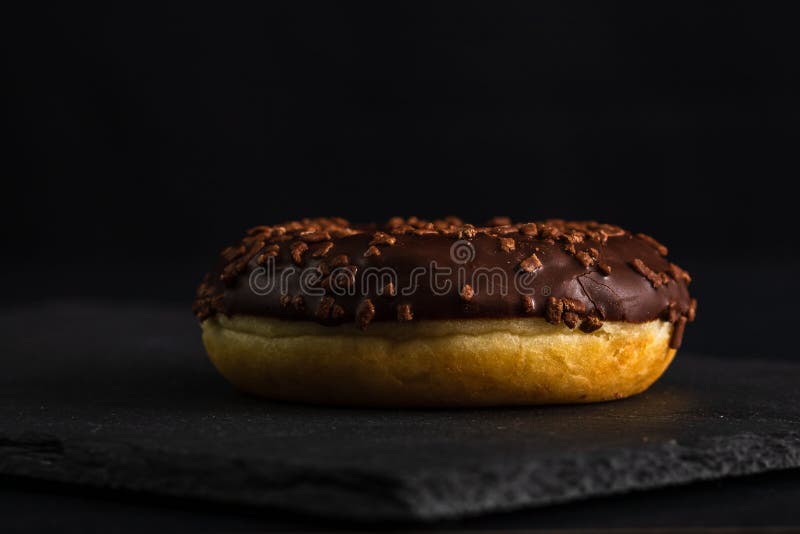 Chocolate glazed donut with chips isolated close up of delicious stock afbeeldingen