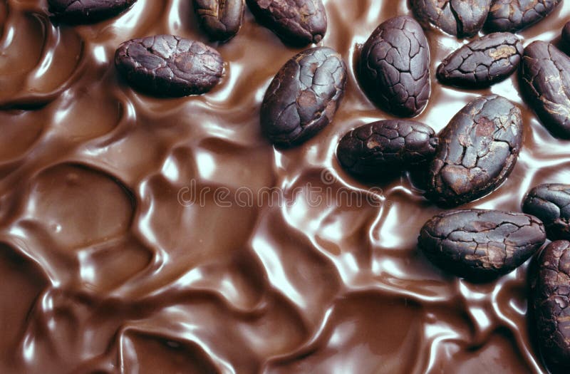 Un'immagine di glassa al cioccolato e fave di cacao.