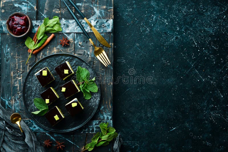 Chocolate Mousse Dessert Opera on a Black Plate with Mint. Top View