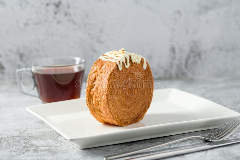 Chocolate New York Roll or Round Croissant with Tea on Stone Table