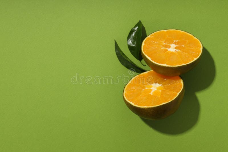 Chocolate Orange Halves with Leaves on Green Background Stock Image