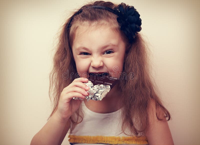 Chocolate oscuro penetrante sonriente de la muchacha del niño de la diversión feliz con anhelar ey foto de archivo Chocolate oscuro penetrante sonriente de la muchacha del niño de la diversión feliz con anhelar ey foto de archivo