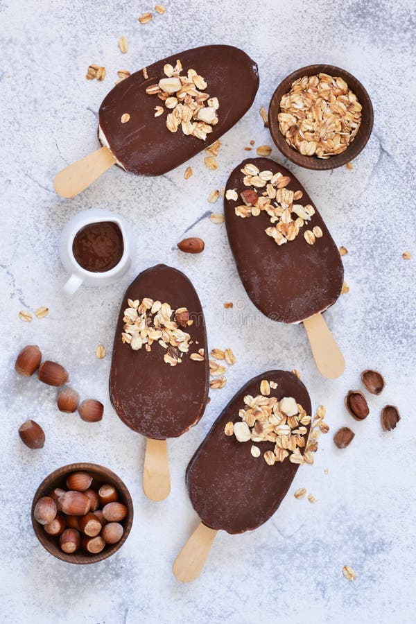 Chocolate Popsicle with Granola and Nuts. Ice Cream on a Concrete