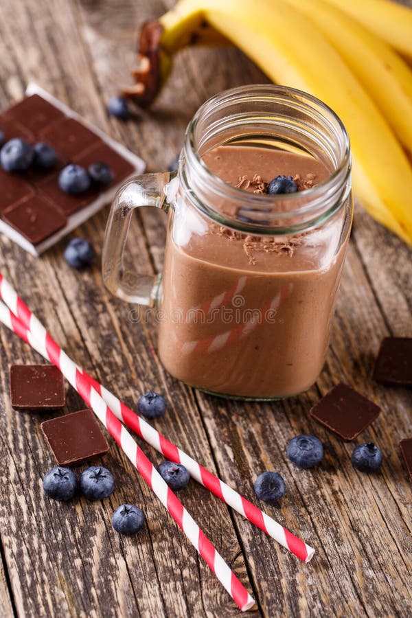 Chocolate Smoothie in Glass Jar with Blueberries and Drinking St Stock