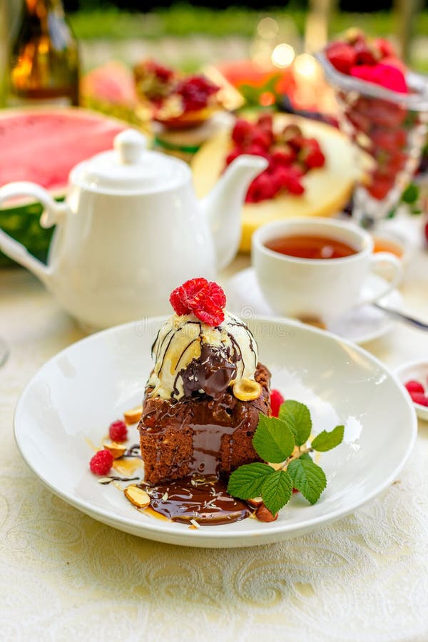Chocolate Sponge Cake with Ice Cream and Fruit on a Served Table Stock