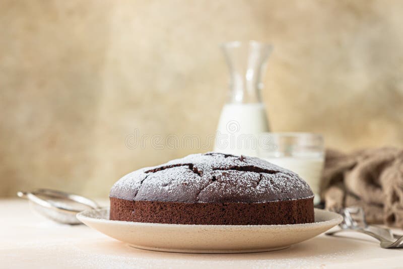 Chocolate sponge flourless cake with sugar powder, light concrete background. Brownie cake. Toned image. Selective focus royalty free stock image
