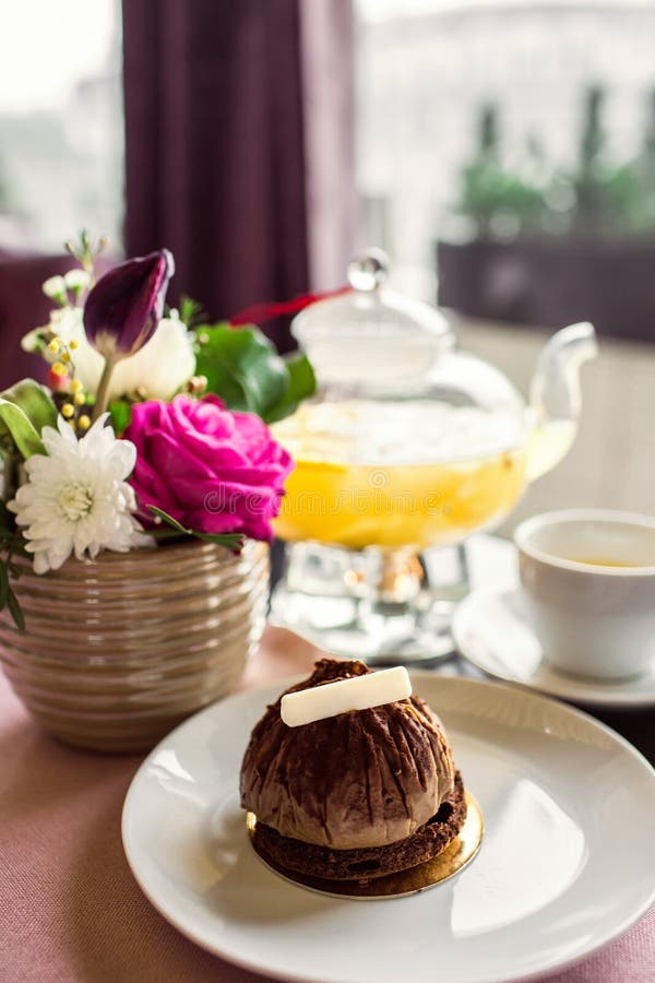 Chocolate truffle cake dessert with white chocolate. Pineapple tea with a transparent glass teapot. Citrus vitamin tea and a beaut