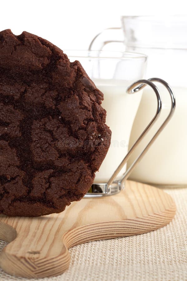 Chocolaty cookie and some milk on background