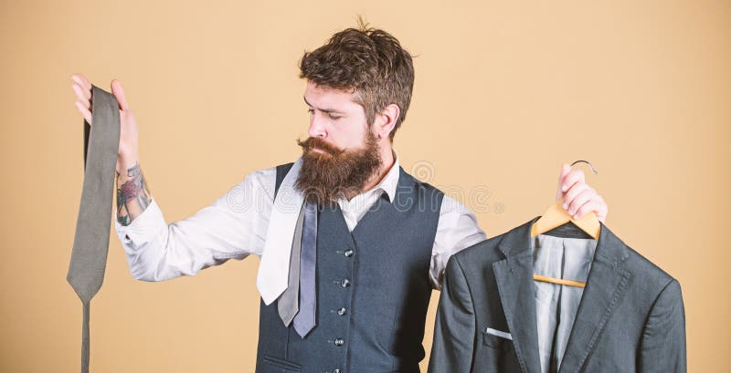 Choice of clothes and accessories. Hipster making shopping choice in shop. Businessman choosing necktie, choice concept. Bearded man matching tie color to suit jacket in store. This is a good choice.