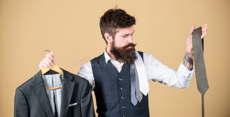 Choice of clothes and accessories. Hipster making shopping choice in shop. Businessman choosing necktie, choice concept. Bearded man matching tie color to suit jacket in store. This is a good choice.