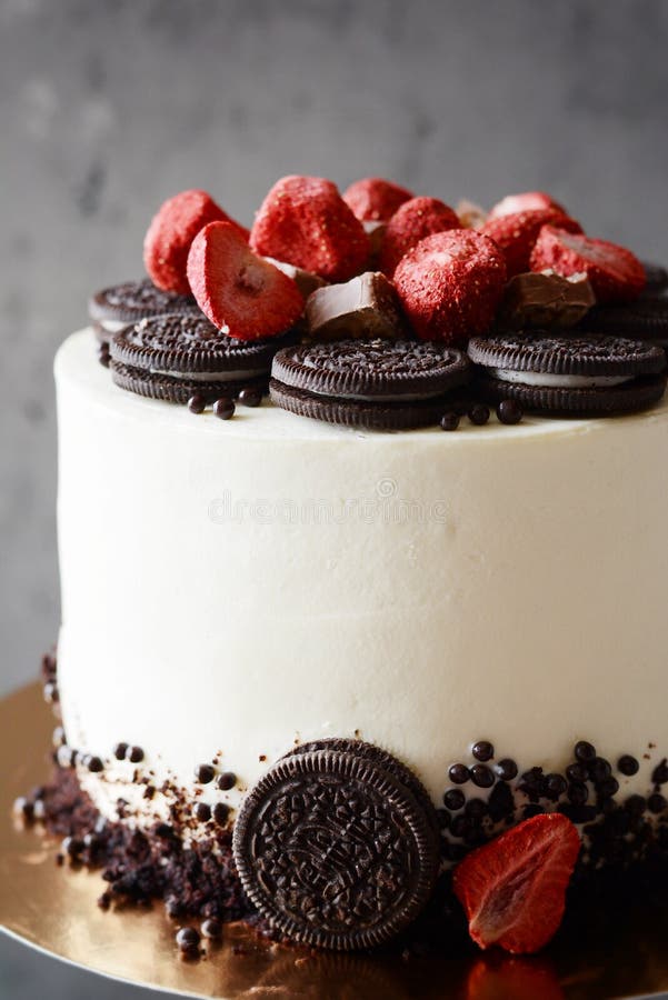 Chokladkaka med gräddostfyllning- och Oreo chokladkakor med frystorkade jordgubbar på en mörk bakgrund fotografering för bildbyråer Chokladkaka med gräddostfyllning- och Oreo chokladkakor med frystorkade jordgubbar på en mörk bakgrund fotografering för bildbyråer