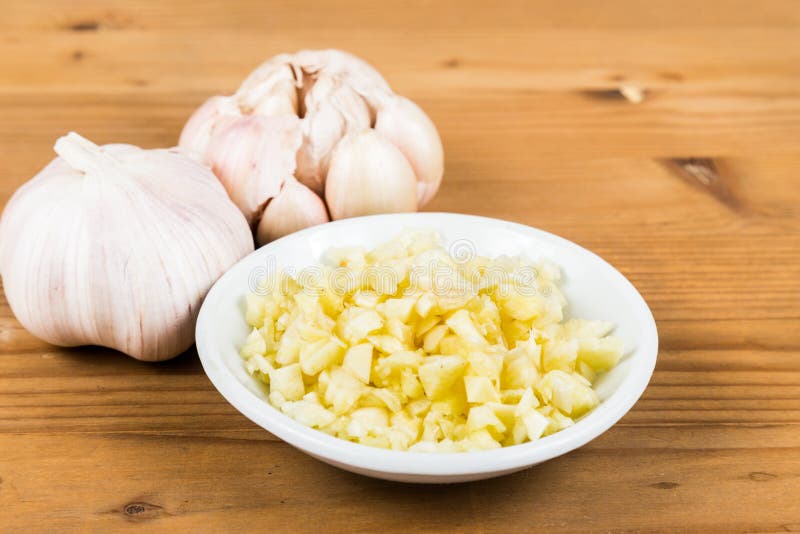 Chopped Garlic in a Plate with Garlic Bulb and Cloves Stock Image