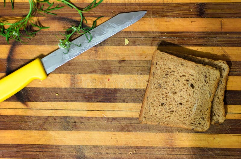 Chopping board with knife, bread and greens stock image Chopping board with knife, bread and greens stock image