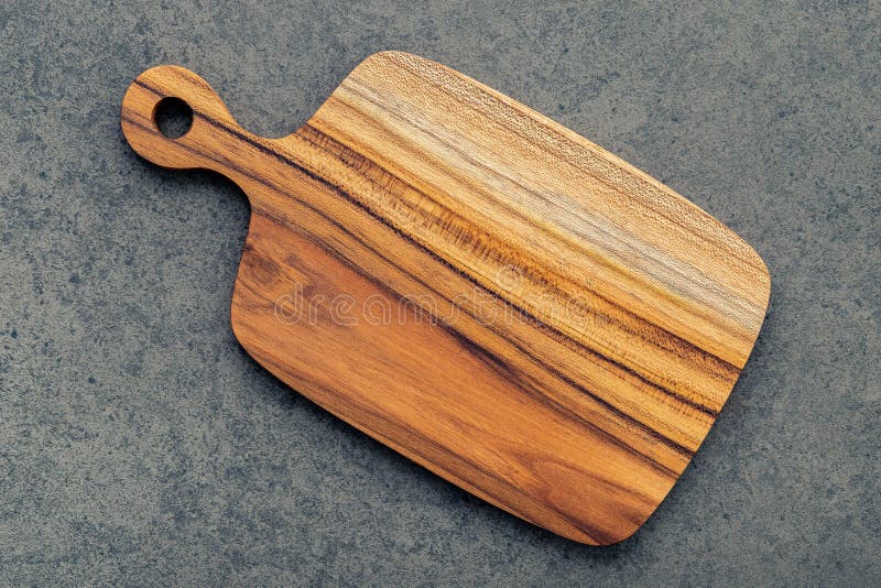 Chopping teak wood cutting board on dark stone background