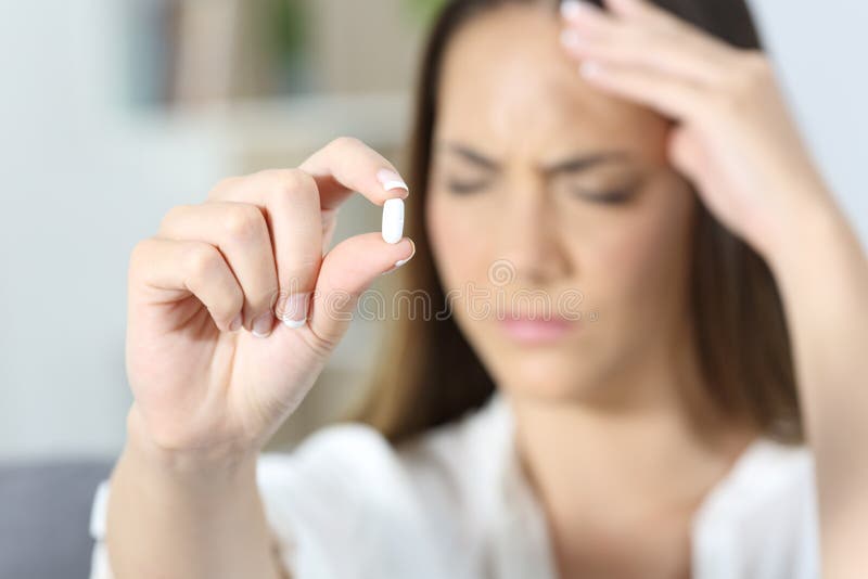 Close up of an ill woman hand showing a painkiller pill. Close up of an ill woman hand showing a painkiller pill