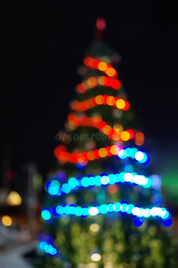 Christmas abstract defocused background, big christmas tree with lights glowing bokeh.