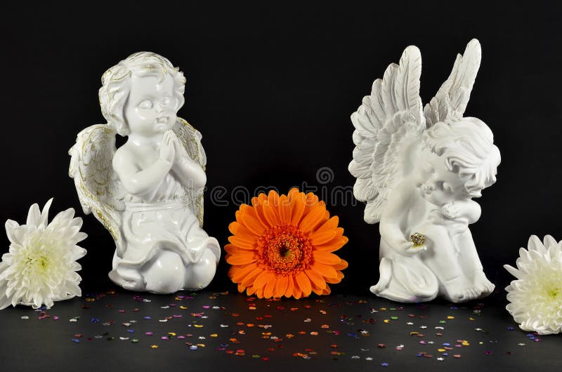 Christmas angels with flowers for gifts, isolated on black