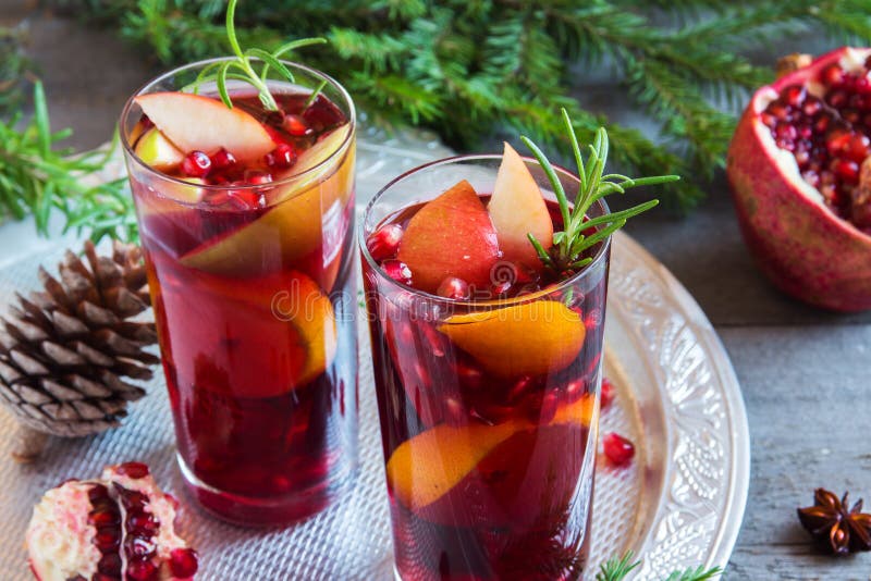 Christmas, autumn or winter sangria with oranges, apples, pomegranate seeds, rosemary and spices - homemade festive drink for Christmas time. Christmas, autumn or winter sangria with oranges, apples, pomegranate seeds, rosemary and spices - homemade festive drink for Christmas time