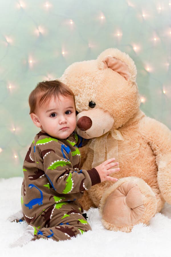 Christmas baby in pajamas hugging teddy bear royalty free stock photography...