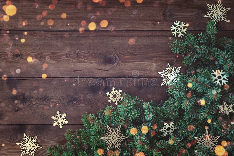 Christmas background with border of fluffy green fir branches on a textured dark brown board