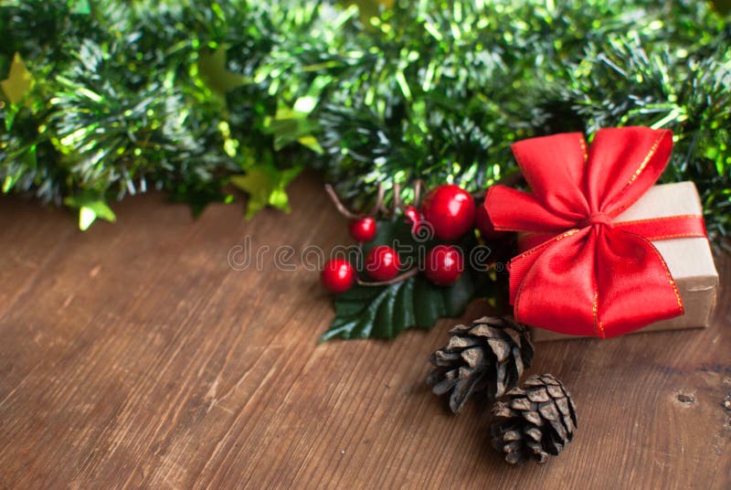 Christmas background with decorative composition of green tinsel, dried oranges, red berres, pine cone, gift with red bow and royalty free stock photography Christmas background with decorative composition of green tinsel, dried oranges, red berres, pine cone, gift with red bow and royalty free stock photography