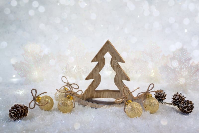 Christmas background with decorative wooden tree and golden glitter ornaments. On the snow background royalty free stock images Christmas background with decorative wooden tree and golden glitter ornaments. On the snow background royalty free stock images
