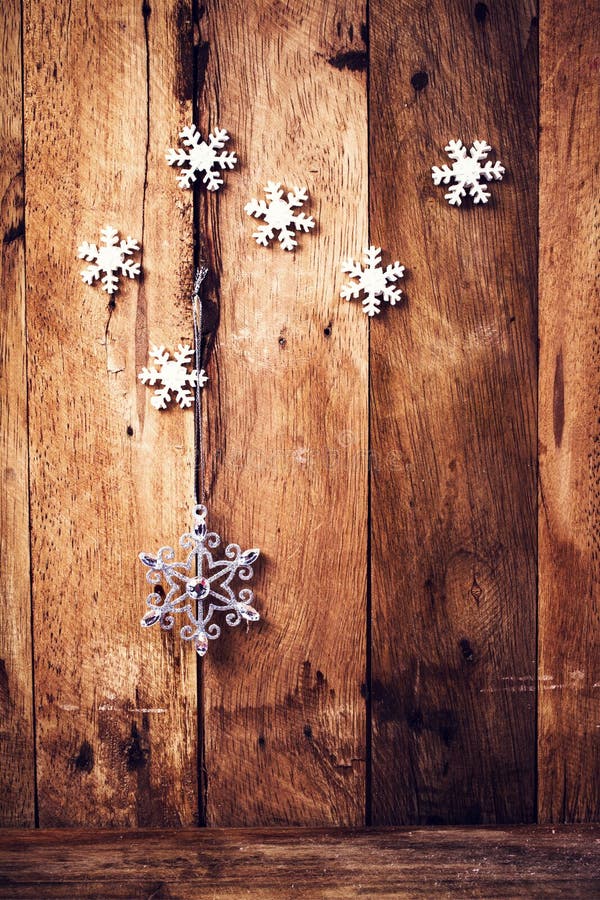 Christmas background with festive ornaments and snowflakes on old wooden wall. Old fashioned Christmas Decoration with copyspace.