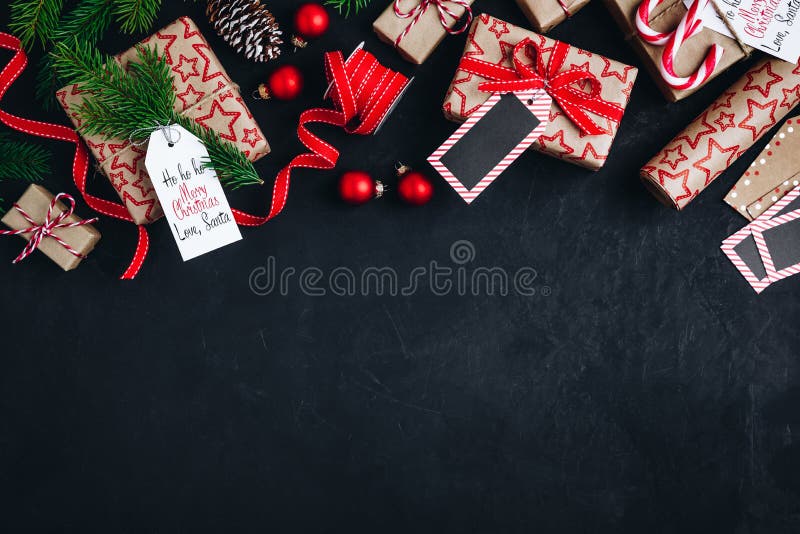 Christmas background with fir branches and cones gift boxes with red bow ribbon on a dark concrete background. Top view, copy space