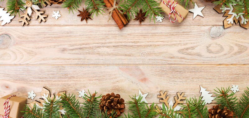 Christmas background with fir tree and gift box on wooden table. Top view banner with copy space for your design