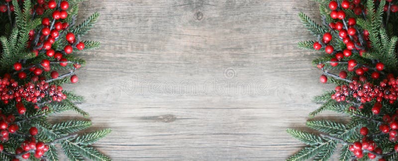 Christmas Background with Rustic Evergreen Pine Branches and Red Berries Over Wood Texture