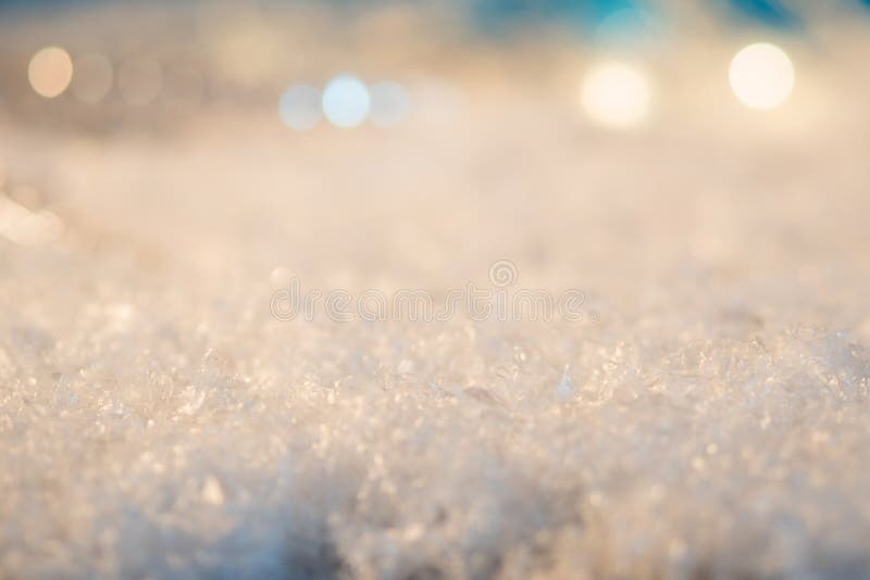 Christmas background. The snow in foreground, festive lights in the background