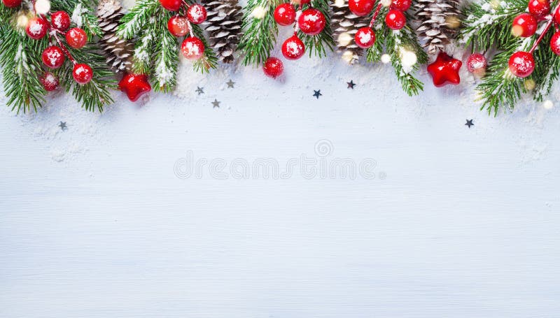 Christmas background with snowy fir branches, cones and bokeh lights. Holiday banner or card