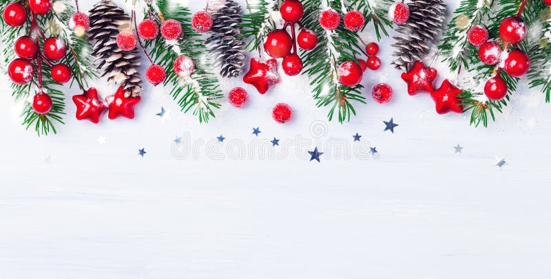 Christmas background with snowy fir branches, cones and red berry. Banner format