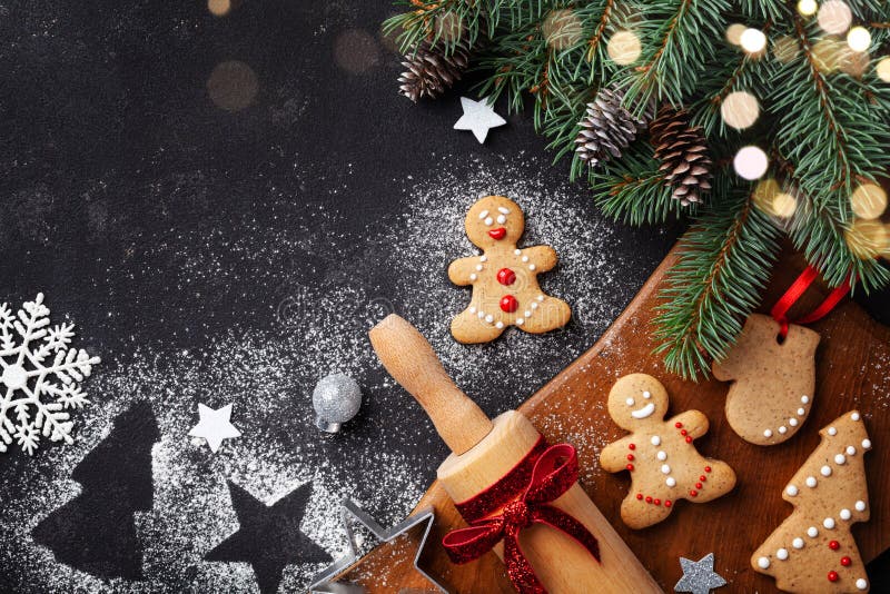 Christmas baking background. Gingerbread cookies, rolling pin and fir tree top view. Homemade sweet pastries for winter holidays