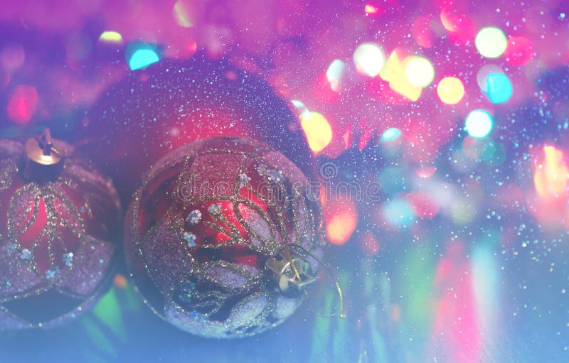 Christmas ball close-up on the background of lanterns blurred by a purple and blue background and running snow.
