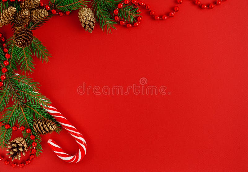 Christmas border composition with candy cane on red background. Top view, copy space