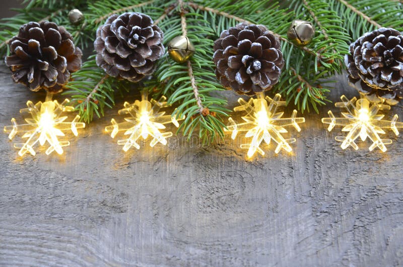 Christmas border decoration with fir tree,pine cones and garland lights on old wooden background. stock photography Christmas border decoration with fir tree,pine cones and garland lights on old wooden background. stock photography