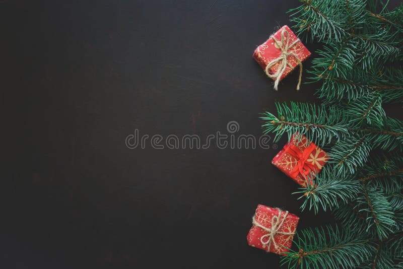 Christmas Border. Fir tree branches with gift boxes on dark wooden background. Top view. Copy space. royalty free stock images Christmas Border. Fir tree branches with gift boxes on dark wooden background. Top view. Copy space. royalty free stock images