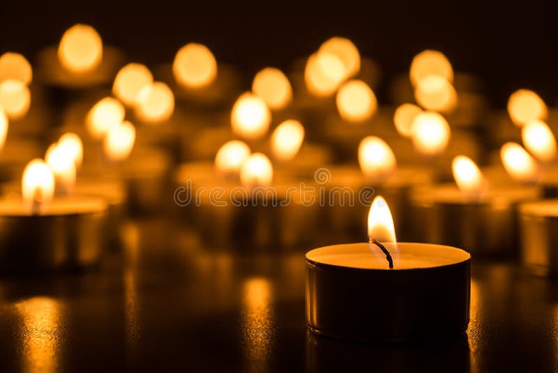 Christmas candles burning at night. Abstract candles background. Golden light of candle flame.